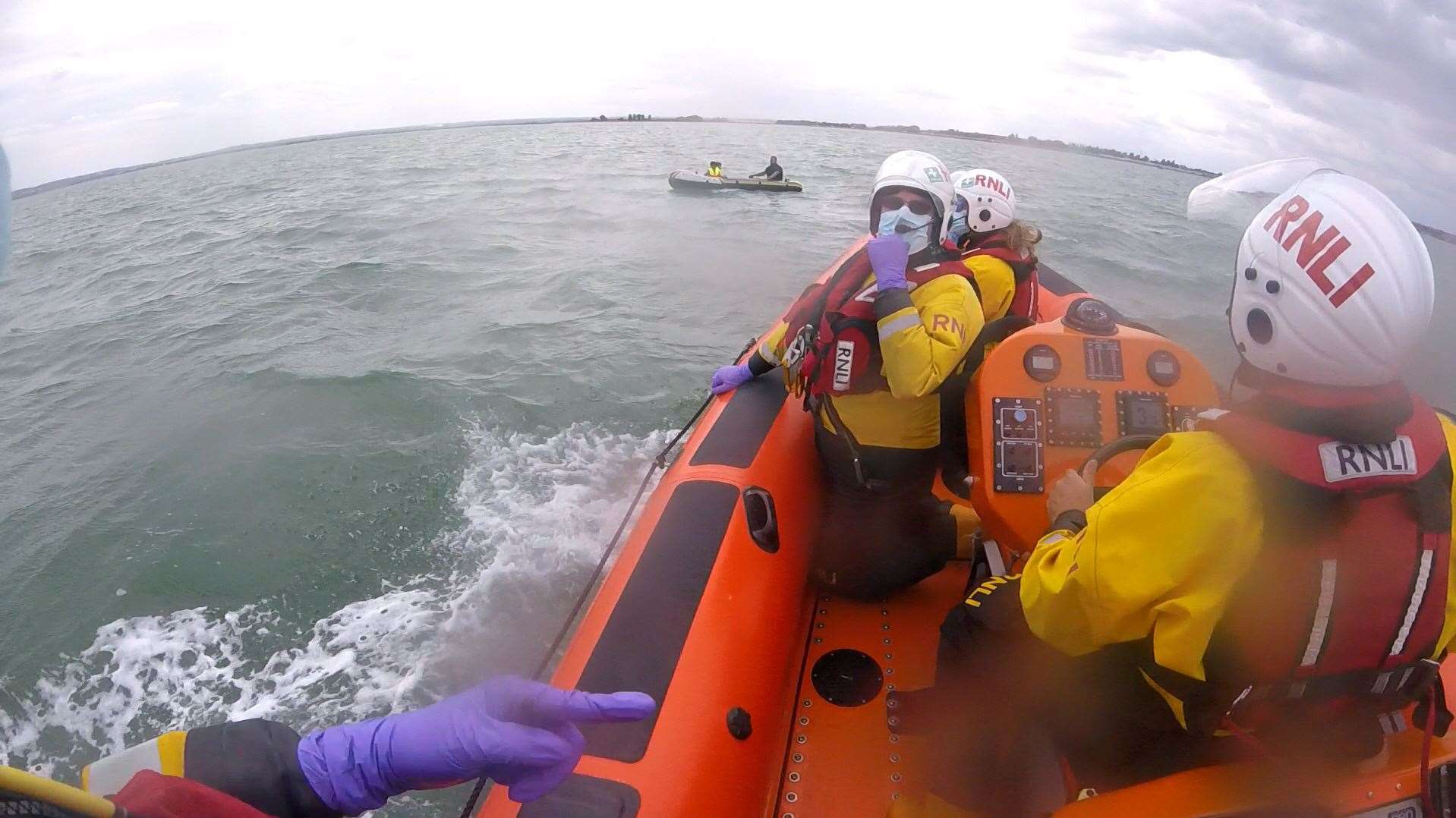 Whitstable lifeboat comes alongside the inflatable dinghy after the craft and it's three occupants were blown offshore from Leysdown, Isle of Sheppey on Tuesday afternoon. Picture: RNLI