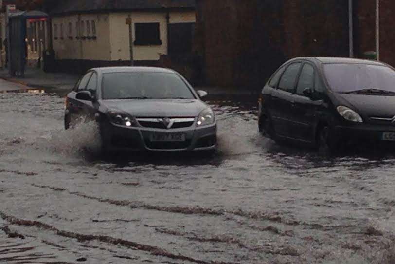 Cars are having difficulty driving through the deluge in New Romney