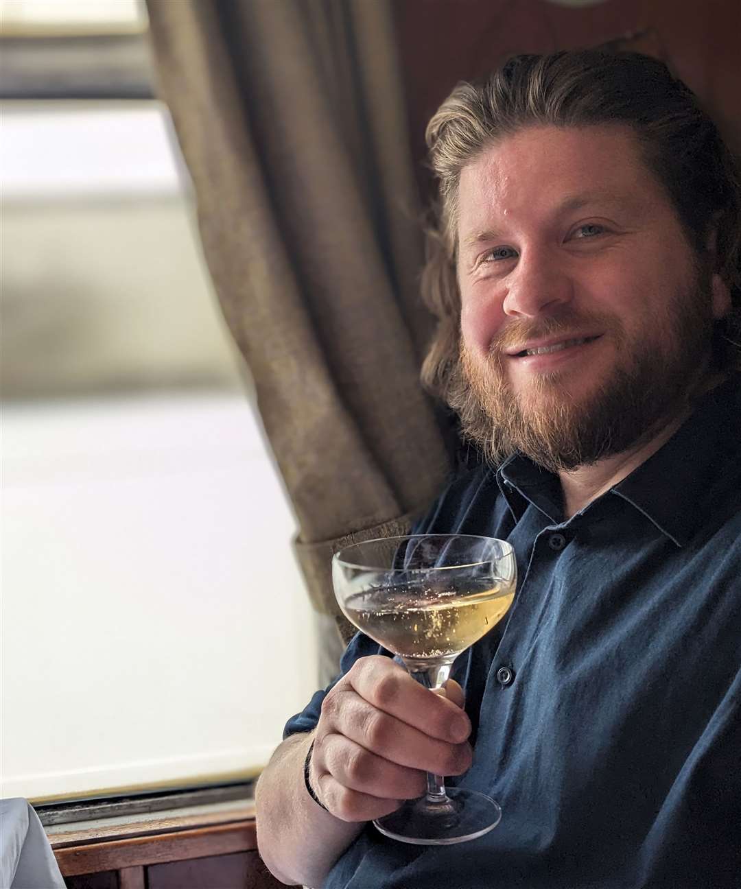 Our man settles in with a glass of bubbly