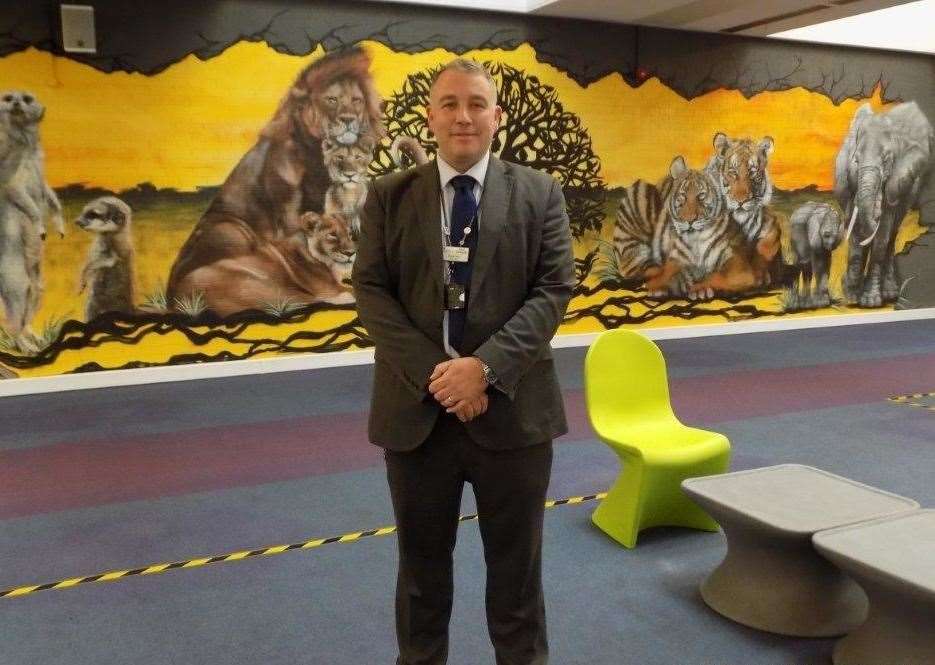 Governor Mark Icke in front of the mural in the visits hall at Swaleside Prison