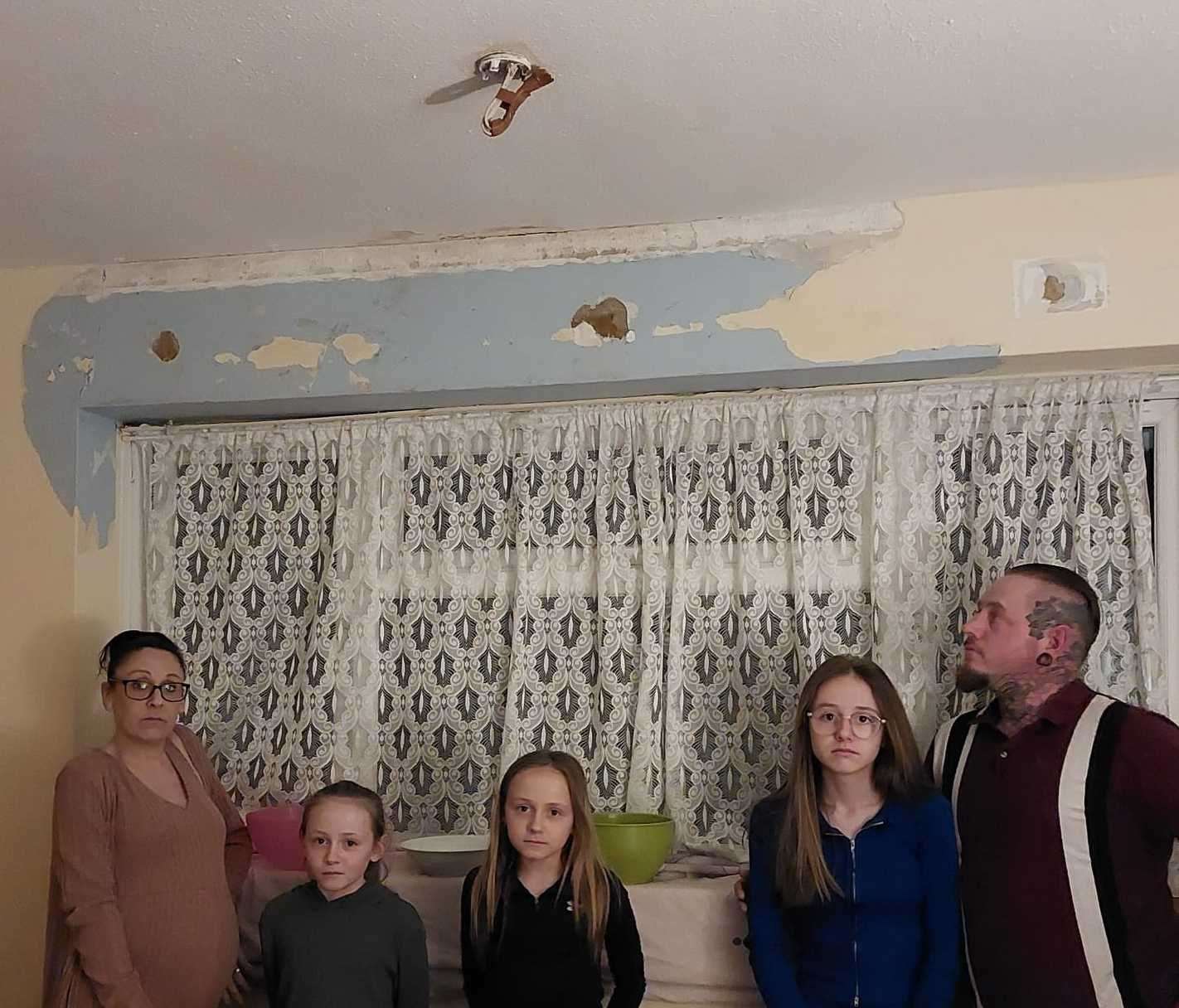 Sam Hutson, Twins Poppy and Daisy Hutson, Caitlyn Hutson, and Luke Hutson standing under their damaged ceiling. Picture: Luke Hutson
