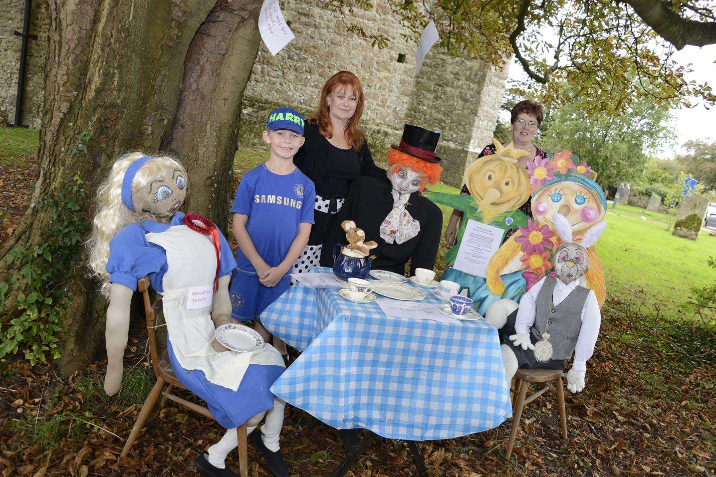 Harry Hinds, 6, Anita Gudge and Linda Andrews join the scarecrow Mad Hatter's Tea Party