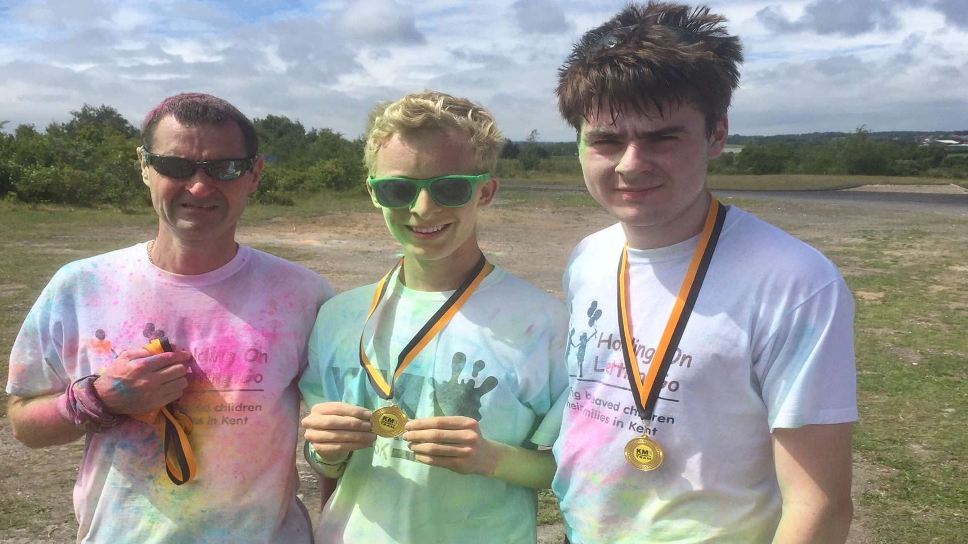 Winner Oliver Richards (centre), 15, from Whitstable, with (left) Steve Jarvis, 44, from Dartford who took third place and his son Michael, 20, (right) who took second place at the KM Colour Run.