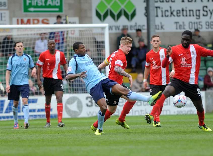 Dartford's Tyrone Sterling (blue) gets stuck in at Lincoln