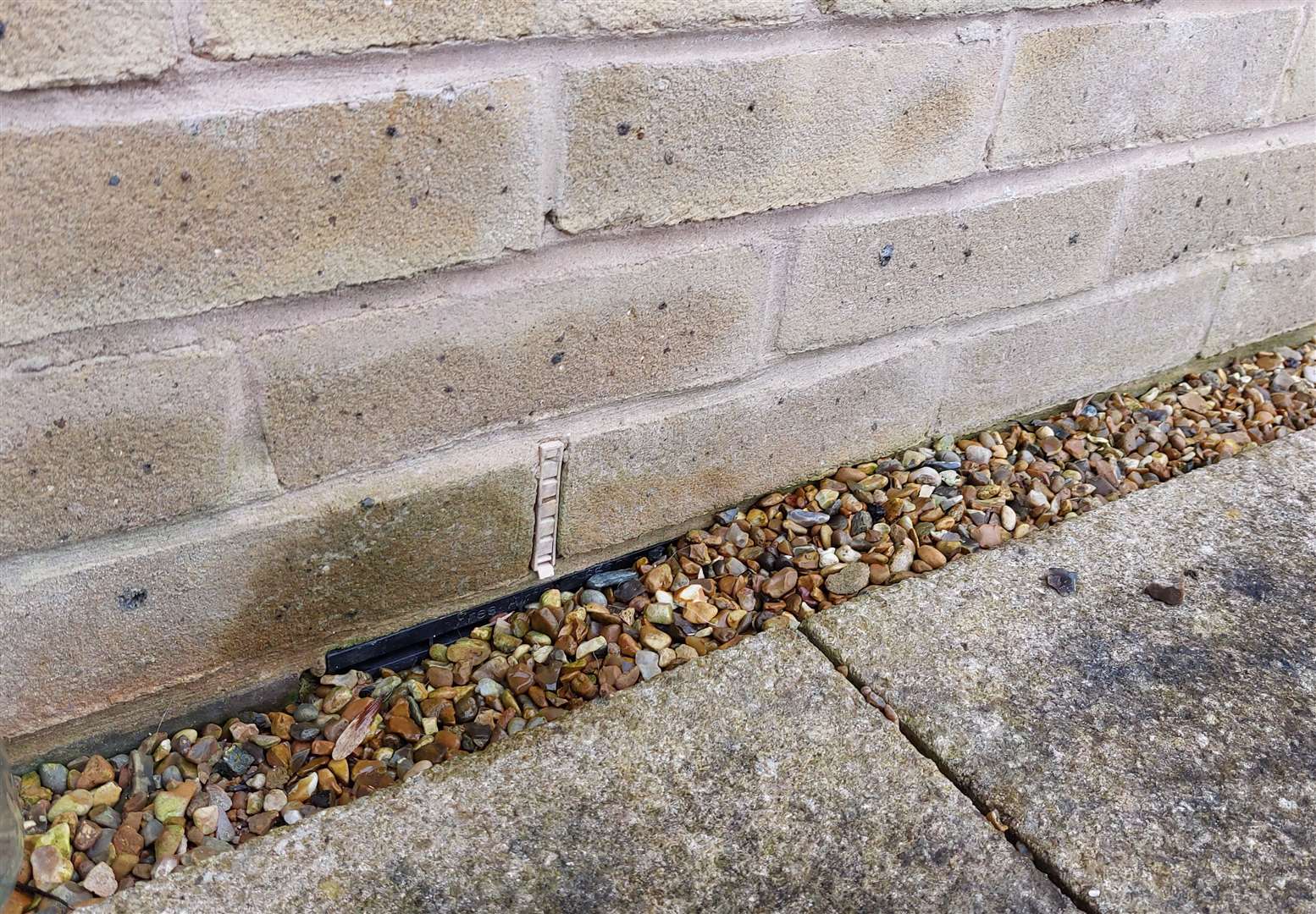 An air brick installed at ground floor level at the Persimmon property and still covered with gravel