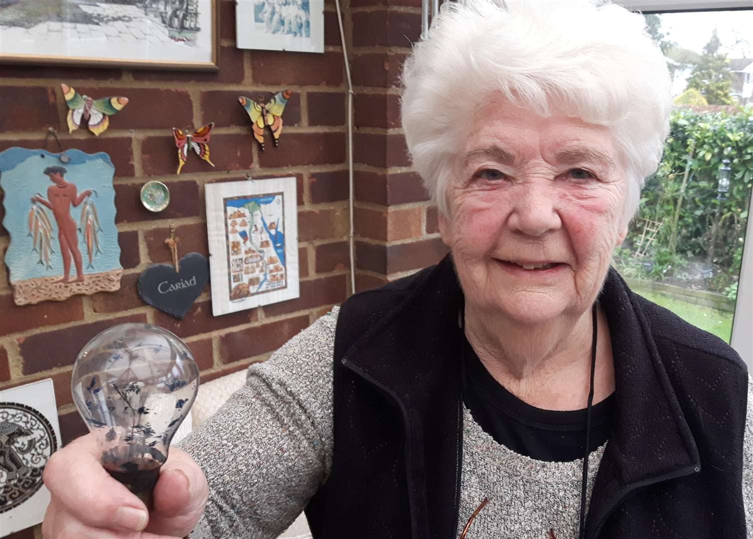 Valerie Beaney and her light bulb which has been in the family since it was bought at Woolies in 1943