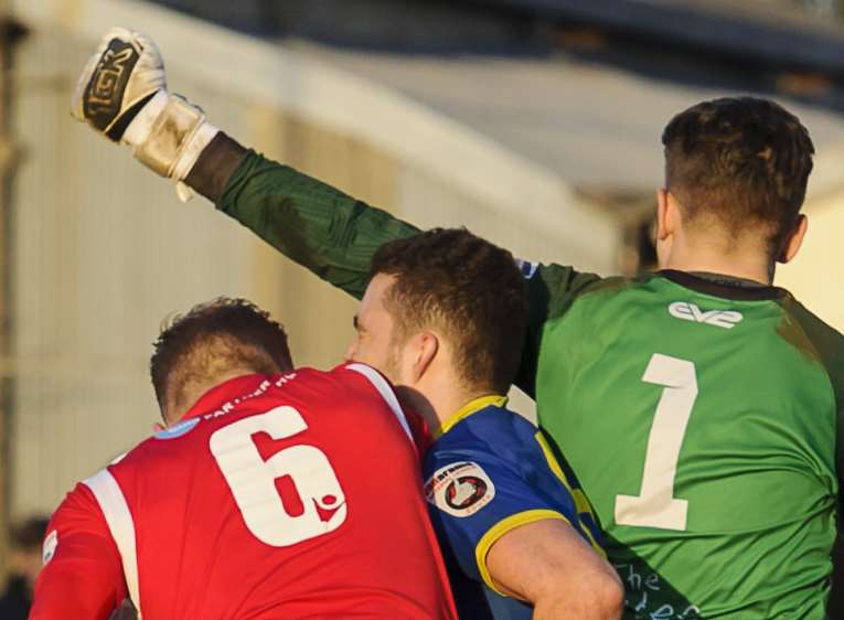 Concord goalkeeper Bailey Vose punches clear from Fleet scorer Kenny Clark