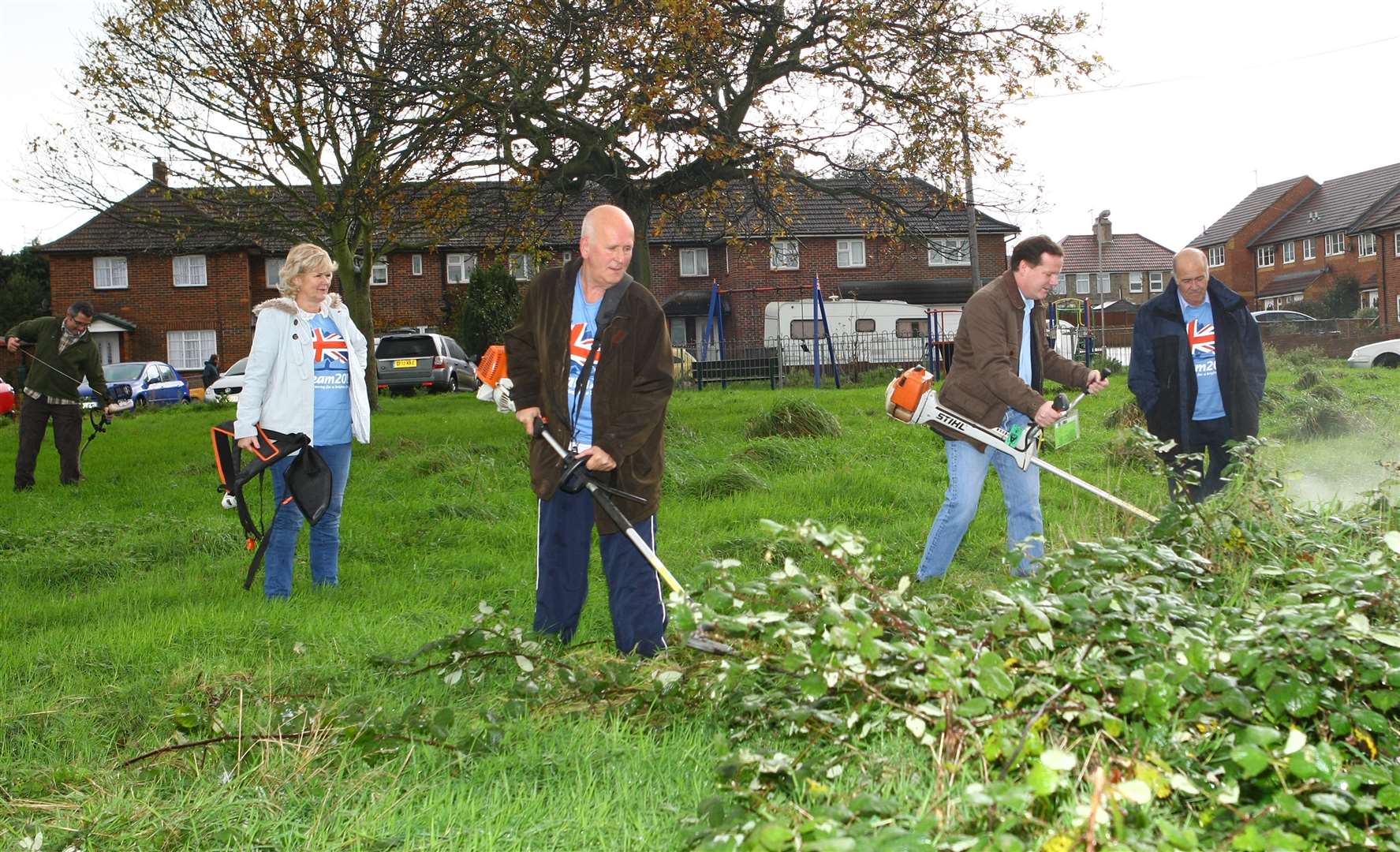 Charlie Elphicke and volunteers cut and clear the grass area in Freemens Way