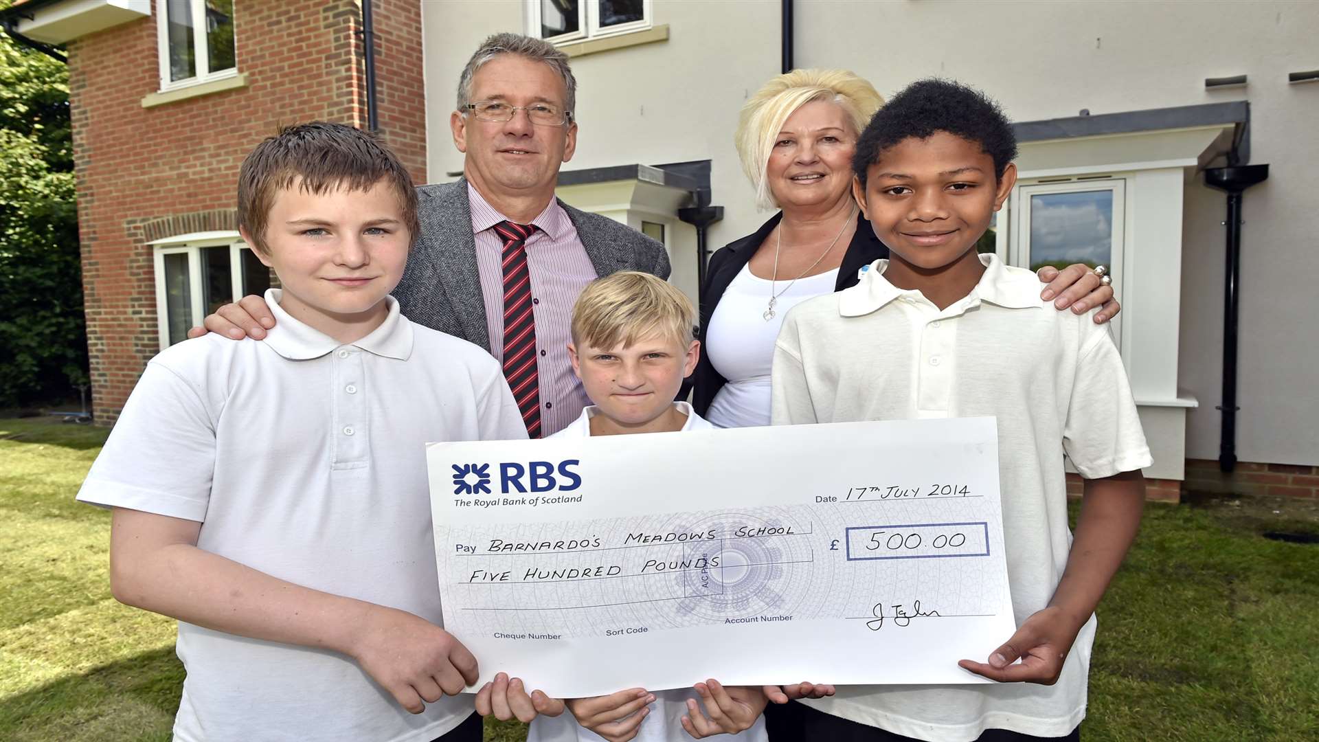 Children from years six and seven at Barnardo's Meadows School, Josh (12), Cameron (10) and Joanito (11) with school principal Mike Price accepting a cheque for £500 to purchase outdoor activity equipment for the school