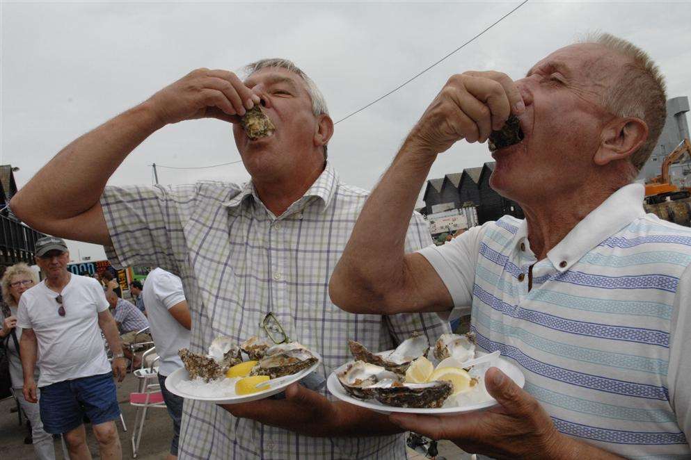Keith Dorey and Joe Steer down some oysters during the Whitstable Oyster Festival on Saturday. Picture: Chris Davey