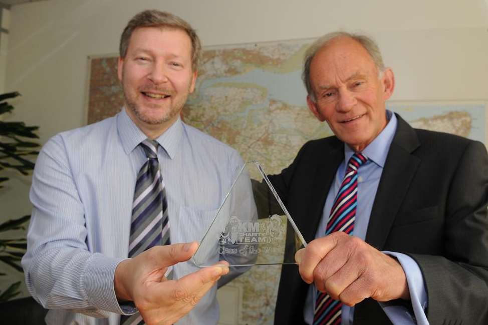 (Left to right) Simon Dolby shows Cllr David Brazier, KCC’s cabinet member for environment and transport, a Green Class of the Week trophy during talks on the importance of walking to school