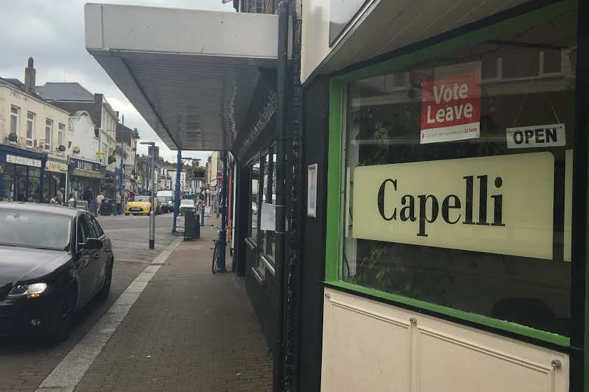 Just one of many businesses with 'leave' posters displayed.