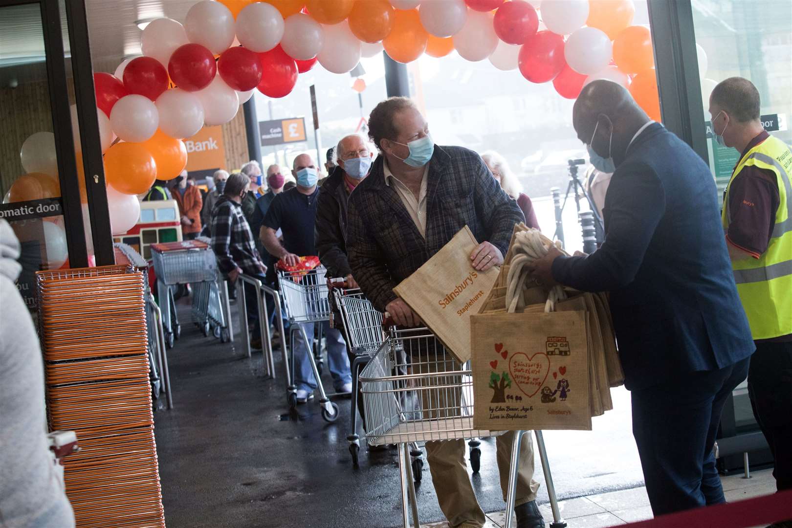 Store manager Kwadwo Osei hands a commemorate bag to customers: Pic Sainsbury's