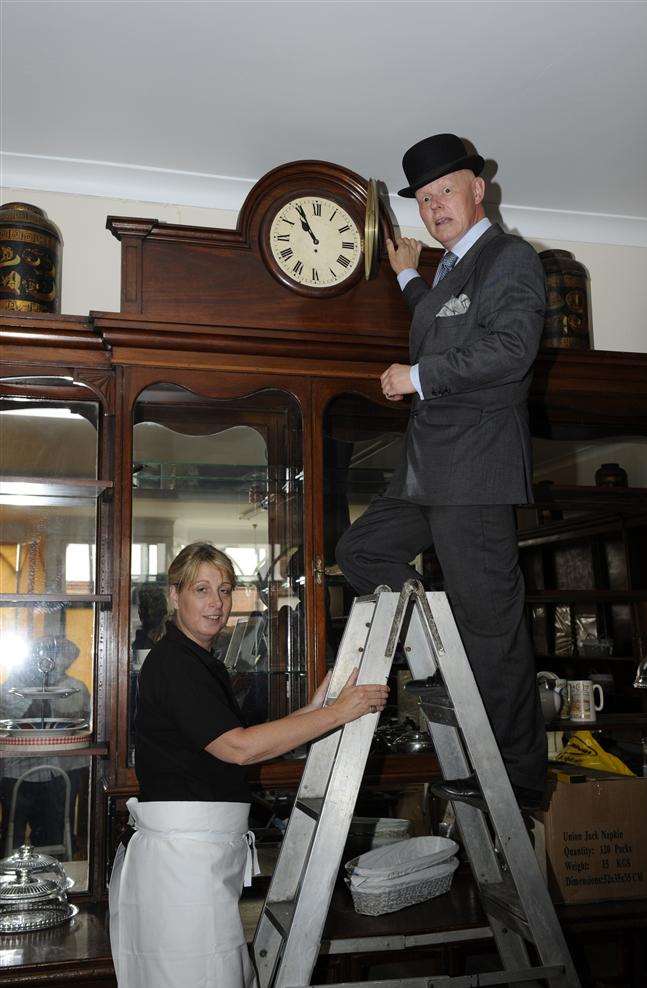 Sandwich clock maker Tim Pettman checks over the clock at Roses Fine Foods with Claire Woods at the bottom of the ladder.