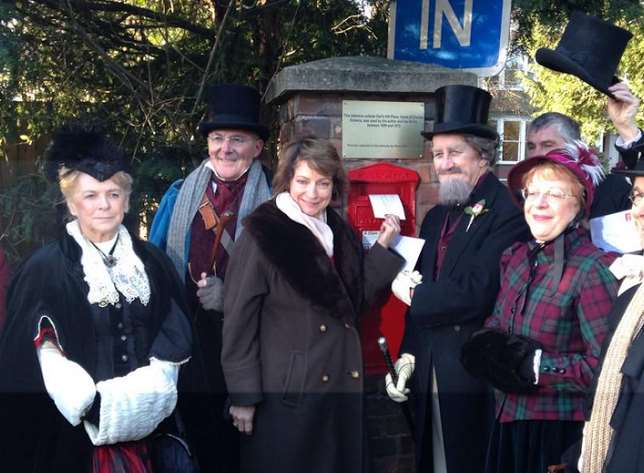 A crowd in 19th century dress at the opening of the post box