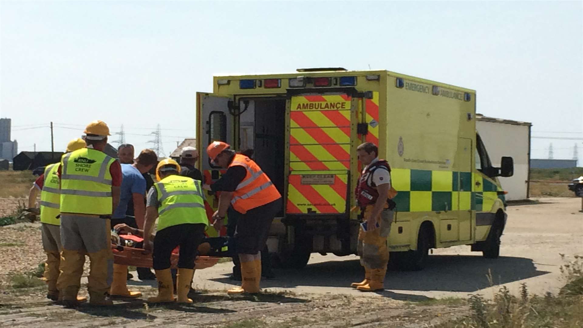 Emergency rescuers attend to the injured man after he's brought ashore. Picture: RNLI