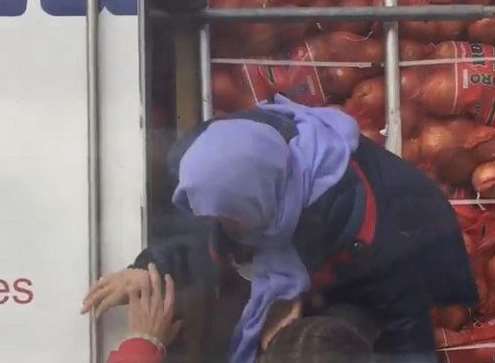 A migrant being helped from a lorry.