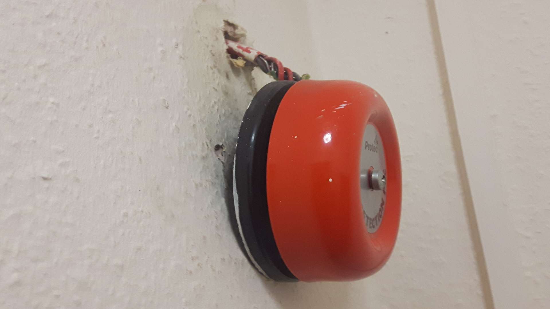 A fire alarm is hanging off the wall
