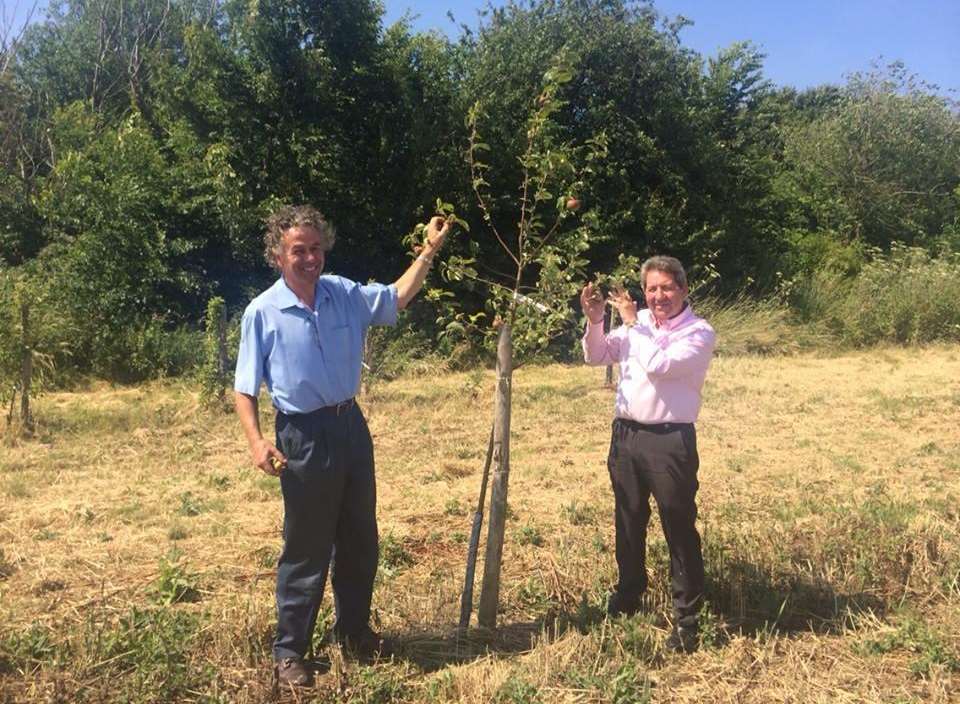 Farmer Oliver Doubleday and Gordon Henderson MP standing next to one of the fruit trees in the community orchard