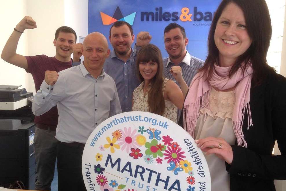 Dee Murphy from the Martha Trust and the team of Miles and Barr rowers who are taking on the KM Dragon Boat challenge for charity