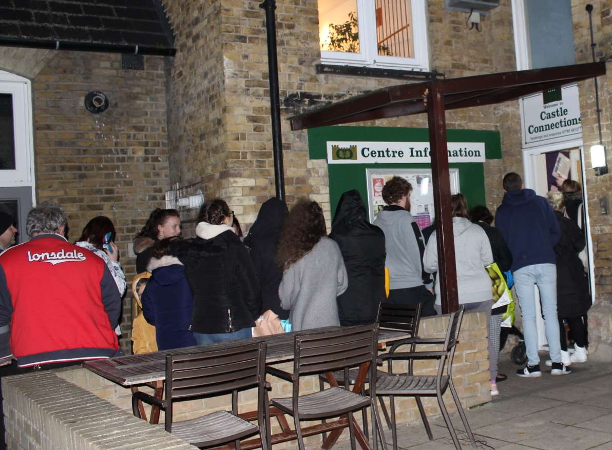 Families queue outside Castle Connections for free food.