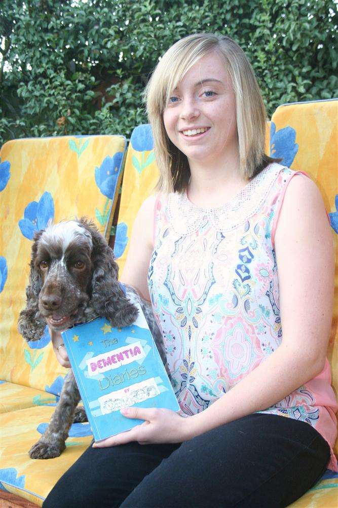 Raisa Hollaway-Hambidge, 17, from Westgate, with her dog Bob, and the newly-launched book The Dementia Diaries, to which she was a major contributor, writing about her grandfathers when they became ill.