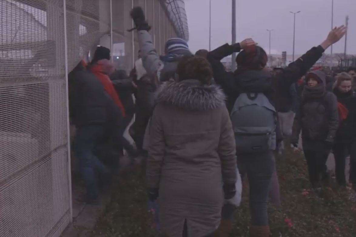 Refugees breaking through a fence at the Port of Calais