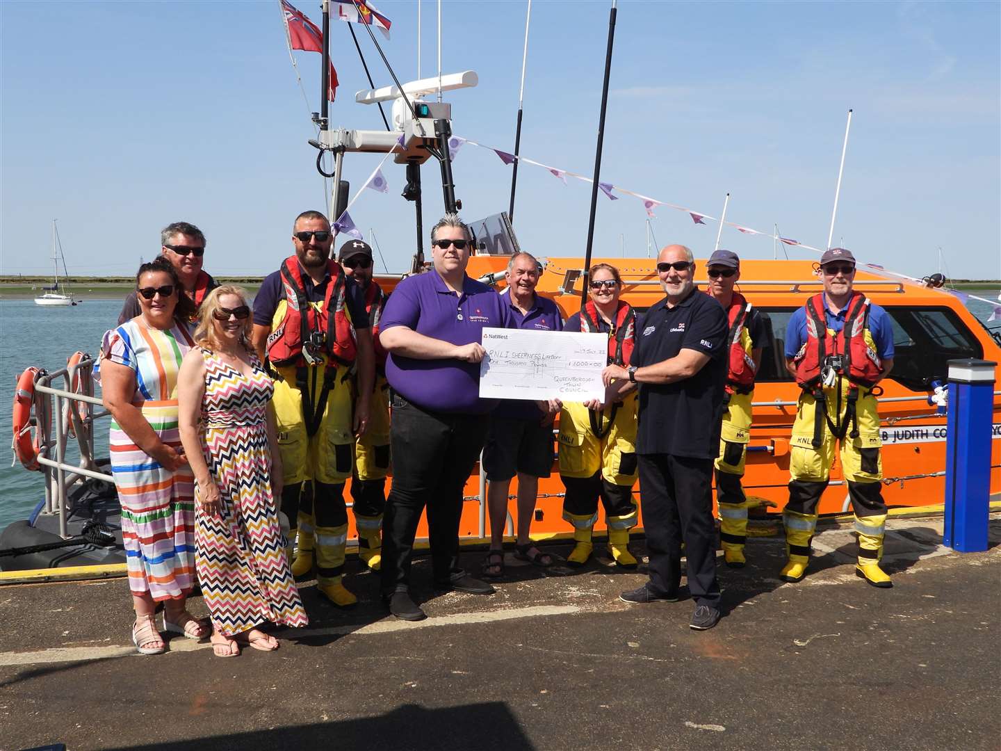 Cllr Cameron Beart of Queenborough Town Council hands over £1,000 to Robin Castle of Sheerness RNLI. Picture: Vic Booth/RNLI