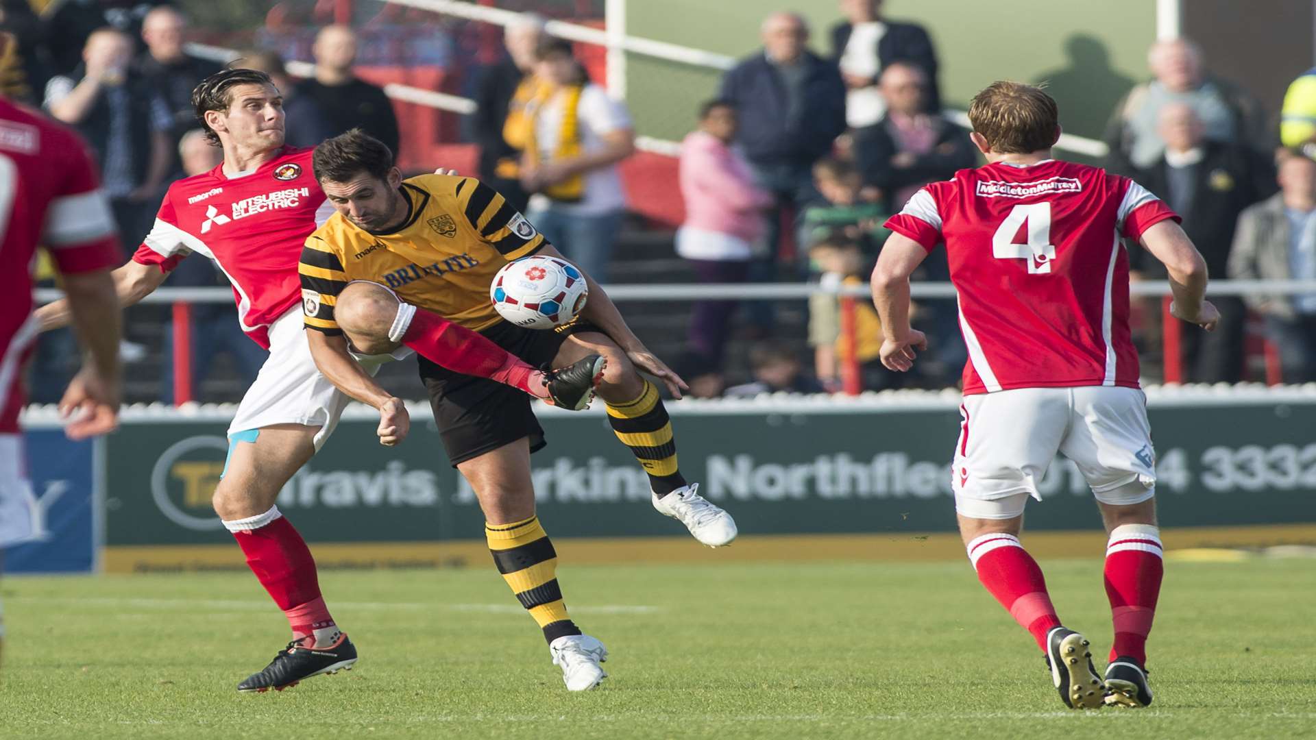 Stuart Lewis (4) looks on as Tom Bonner challenges Maidstone's Jay May Picture: Andy Payton