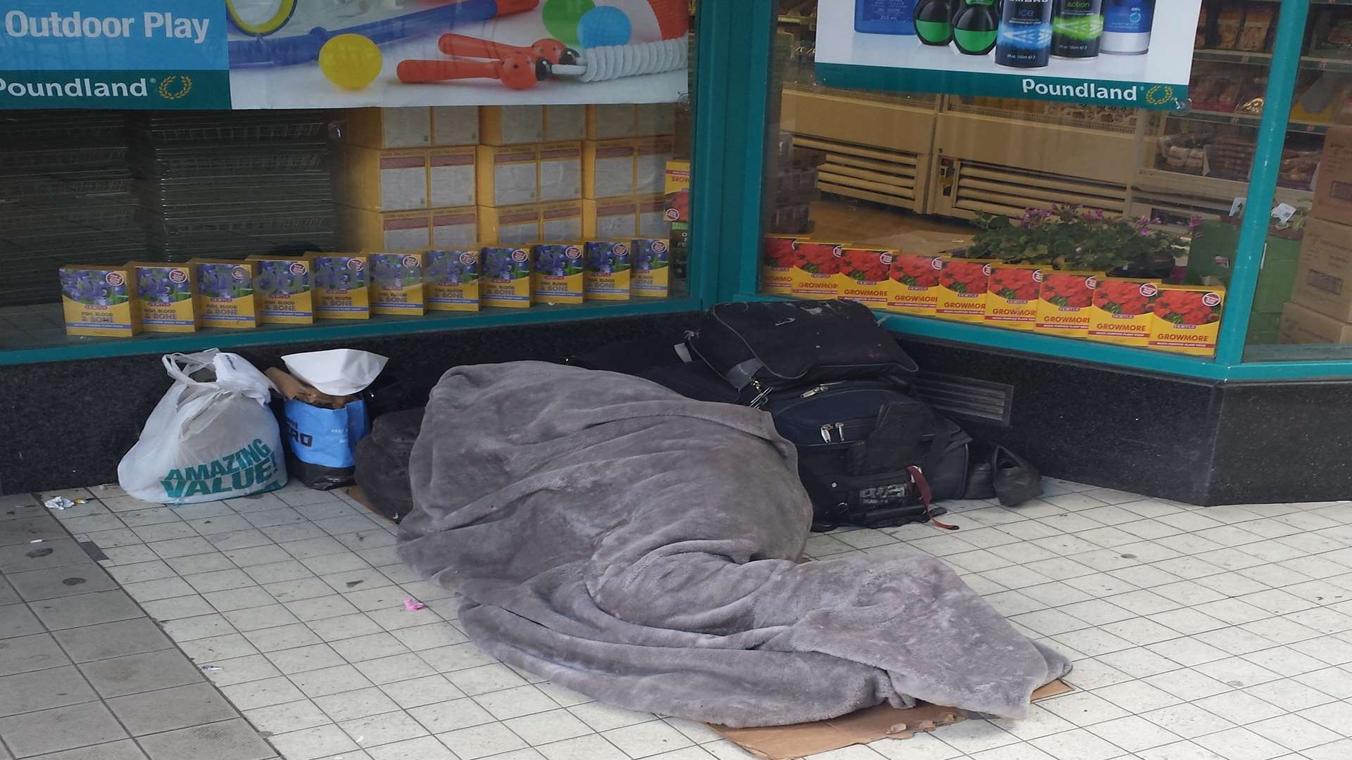 A homeless person sleeping in a shop doorway. Stock image