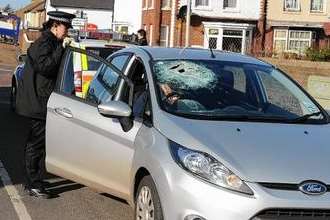 A police officer by a car damaged in the attack