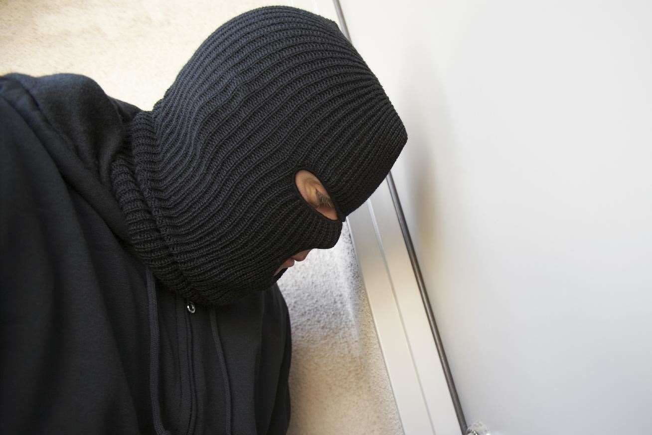 The offender was dressed all in black. Stock photo