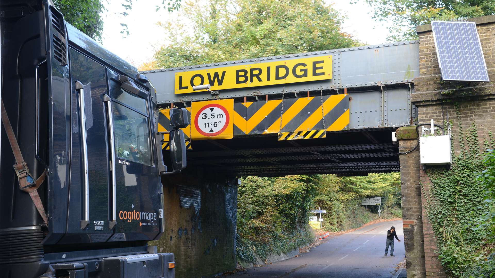 The lorry now freed from the bridge.The driver is pictured nearby.