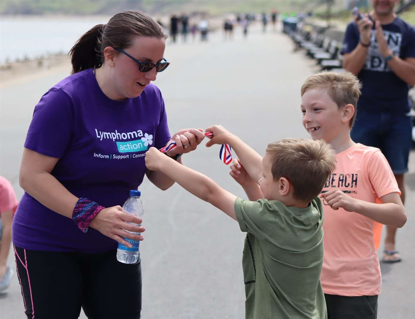 Samuel and Nicholas Nurden present a medal to their mum Tina after she completed a half-marathon at The Leas, Minster, on Sheppey on Sunday