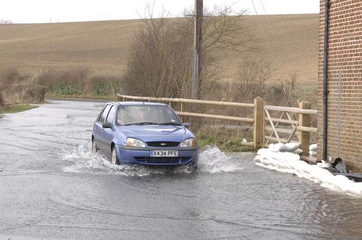 A car drives through a flooded road near Petham. Picture: Chris Davey