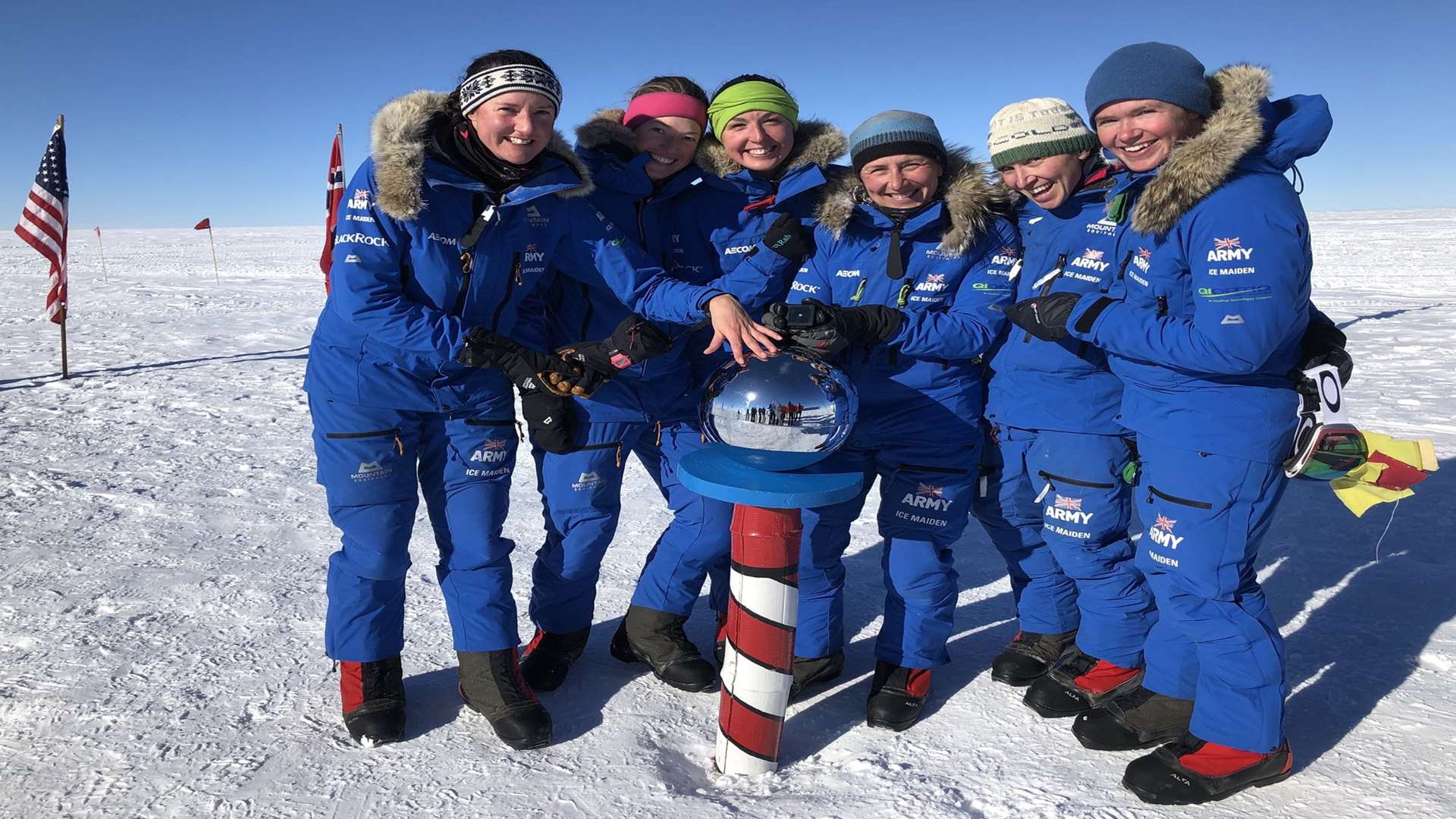 The group touching the silver globe at the South Pole