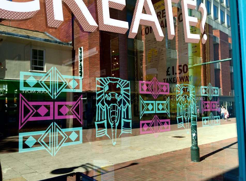 Colourful stickers in the window of Nucleus Arts in Chatham, as part of the Chatham Placemaking project
