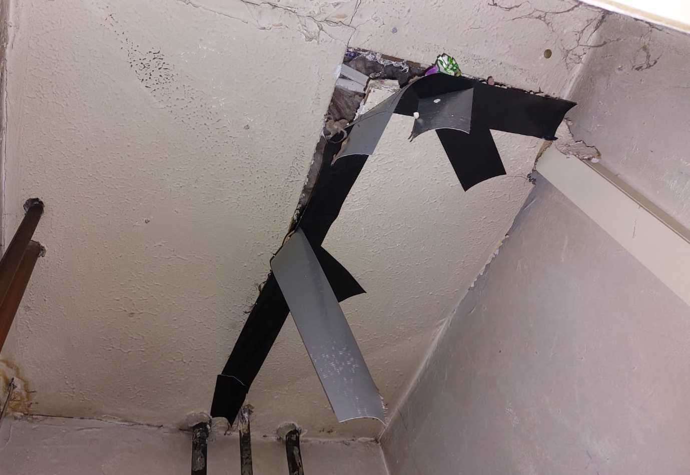 A hole in the ceiling of the airing cupboard, attempted to be taped up. Picture: Luke Hutson
