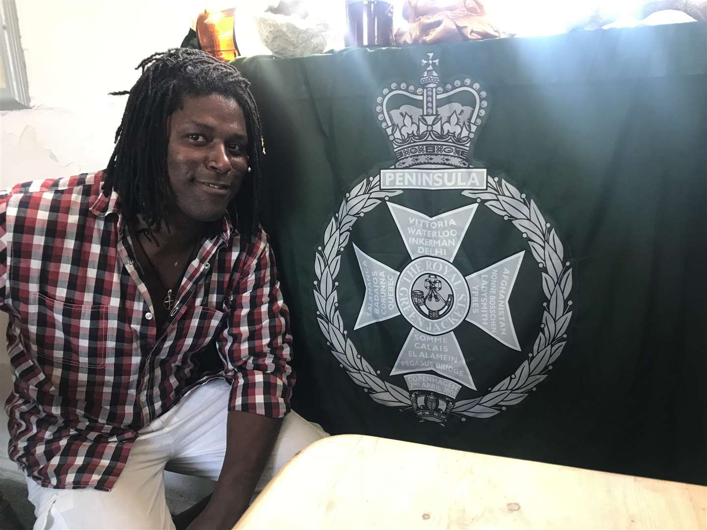 Cafe owner Peter St Ange with the flag given to him by his old colleagues (3221915)