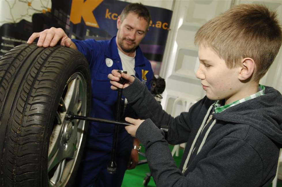 A pupil changes a wheel on the K College stand at last year's Kent Choices4U event
