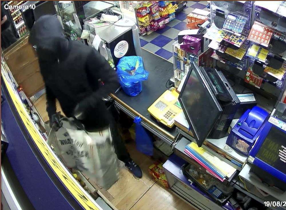 CCTV footage from St John's Mini Market, showing a masked armed robber