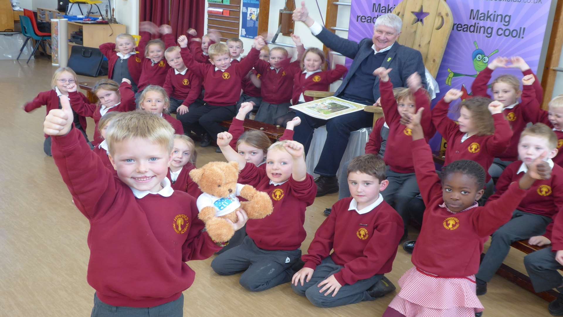 Reiss Coulter, 5, with Buster's mascot Ted cheered on by author and illustrator Nick Butterworth and classmates at Lunsford Primary School, Maidstone. Elephant Class won Kent reading challenge organised through Buster's Book Club.