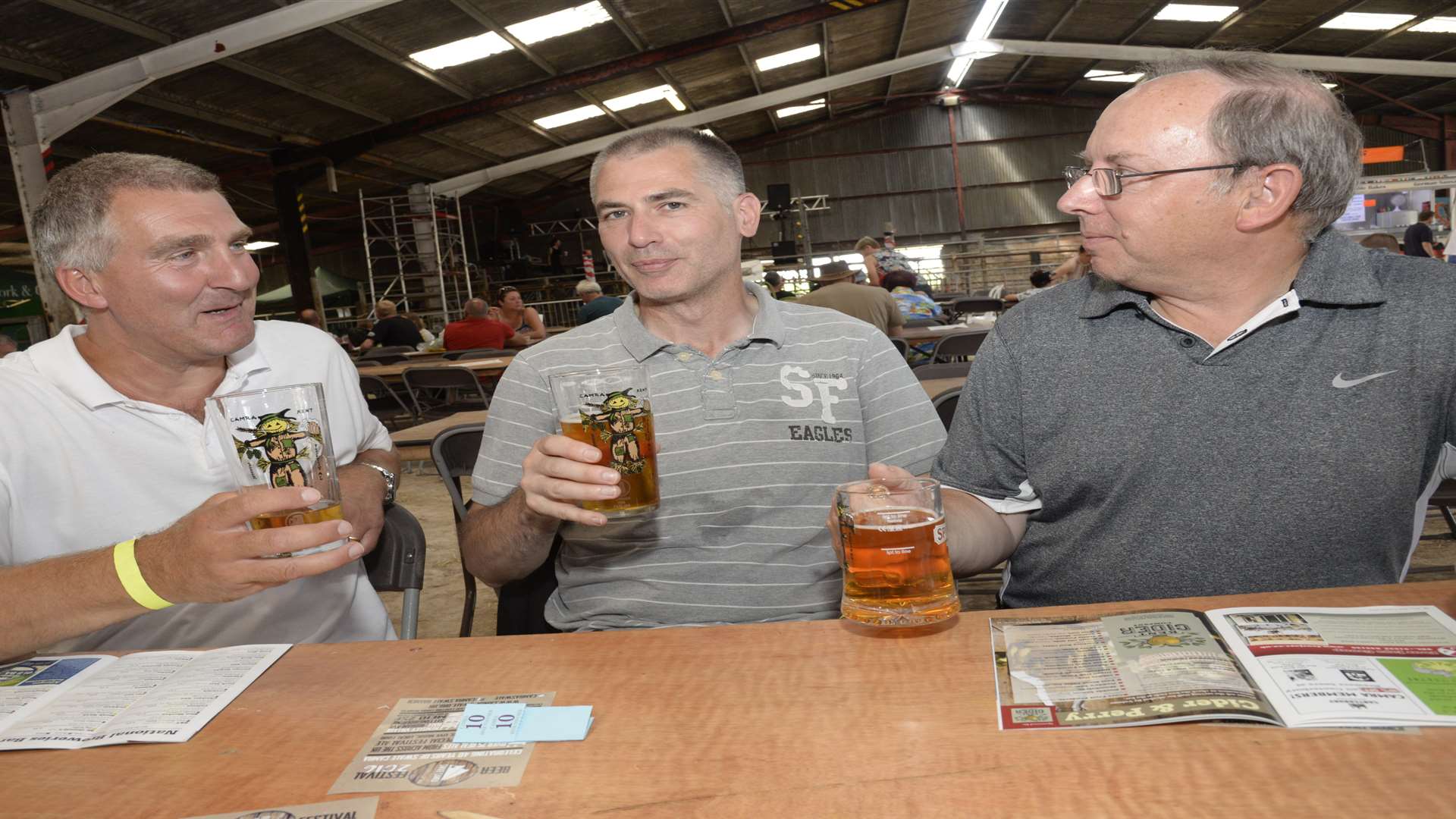 Friends chat over a beer at a previous Kent Beer Festival held at Merton Farm in Canterbury