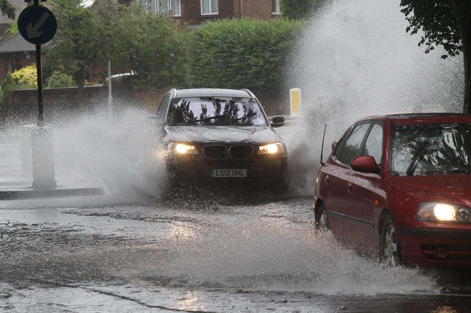 Cars travel through a flooded area on Bell Road in Sittingbourne due to a burst water main