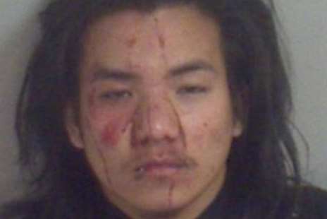 With his face covered in blood, Hitendra Limbu is pictured in a police image after being arrested