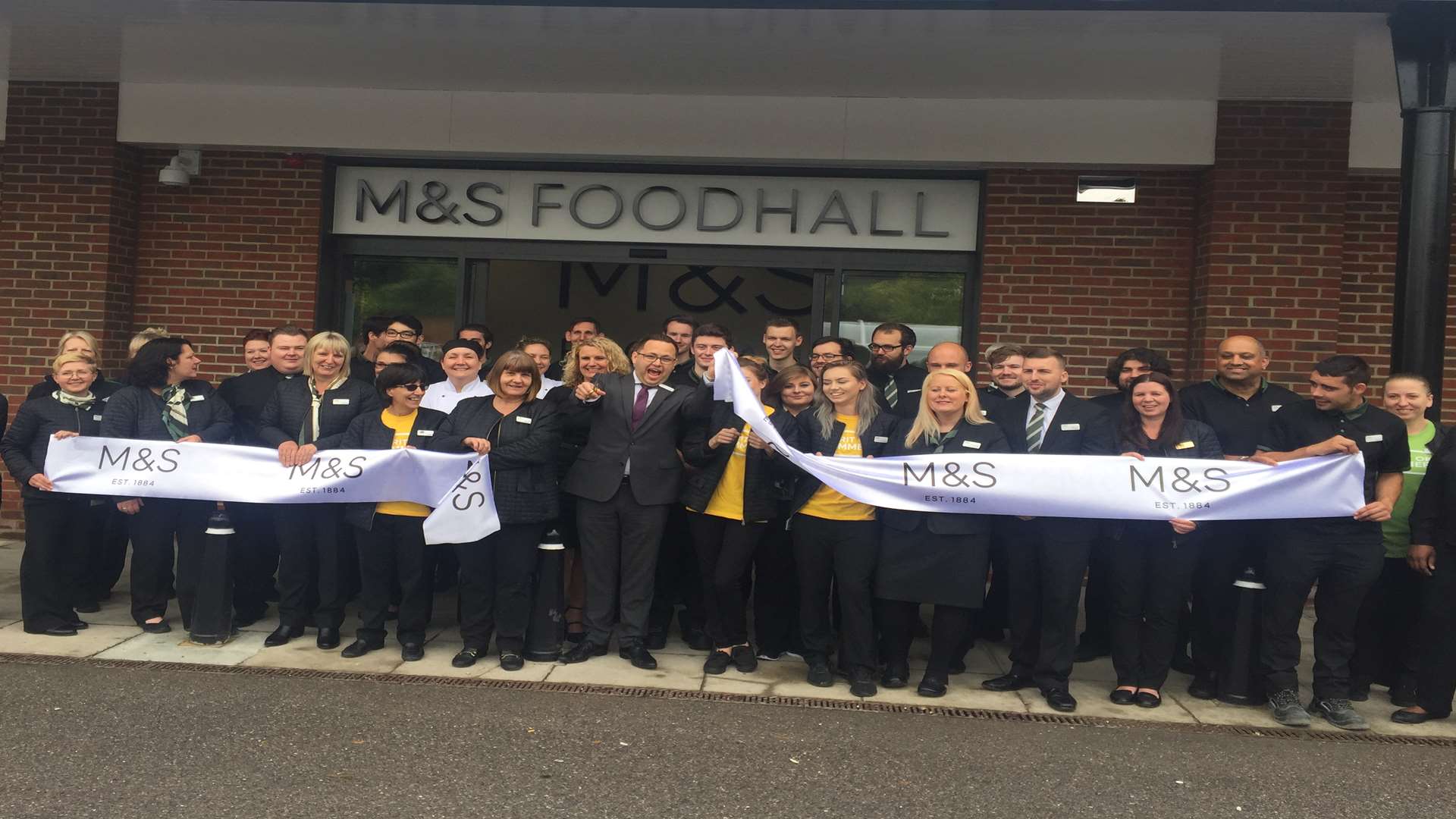 Staff cutting the ribbon at the store opening