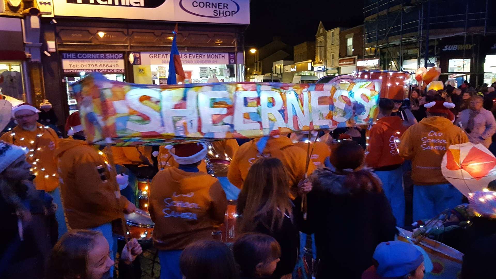A Sheerness sign held up by members of Old School Samba, surrounded by the annual lantern parade, at the Sheerness Christmas lights switch on