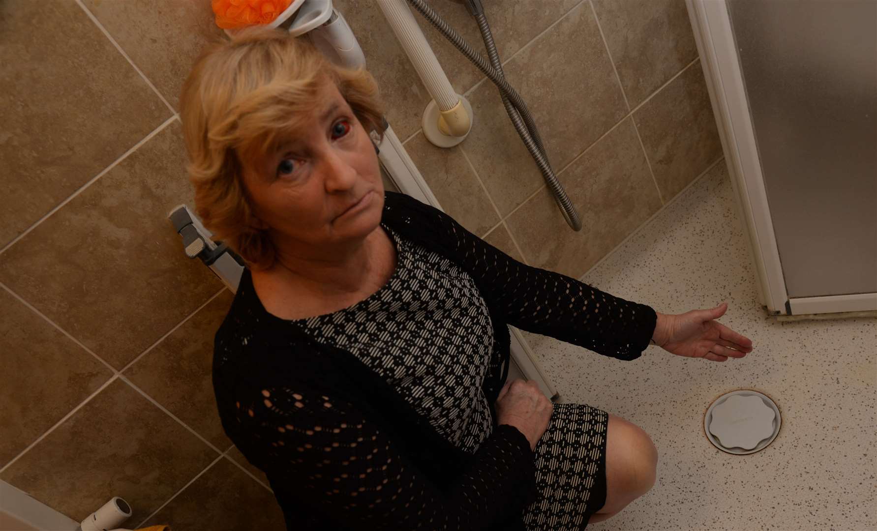 Elizabeth Deveson with the plug in her shower room in her flat at Godfrey House. Picture: Chris Davey