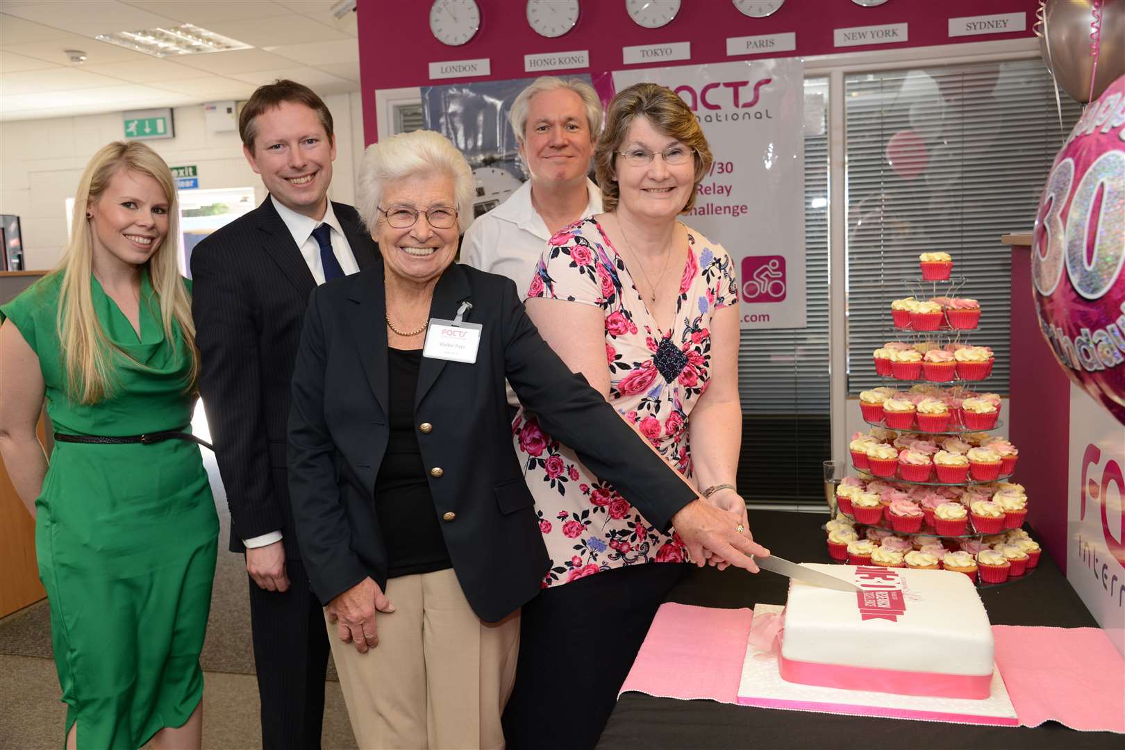 Founder Barbara Lee, centre, and longest-serving employee Barbara Palmer cut the cake for Facts International's 30th birthday with associate director Melanie Eberline-Scott, left, chief executive Crispin Beale, second left, and chairman Nick Lamb