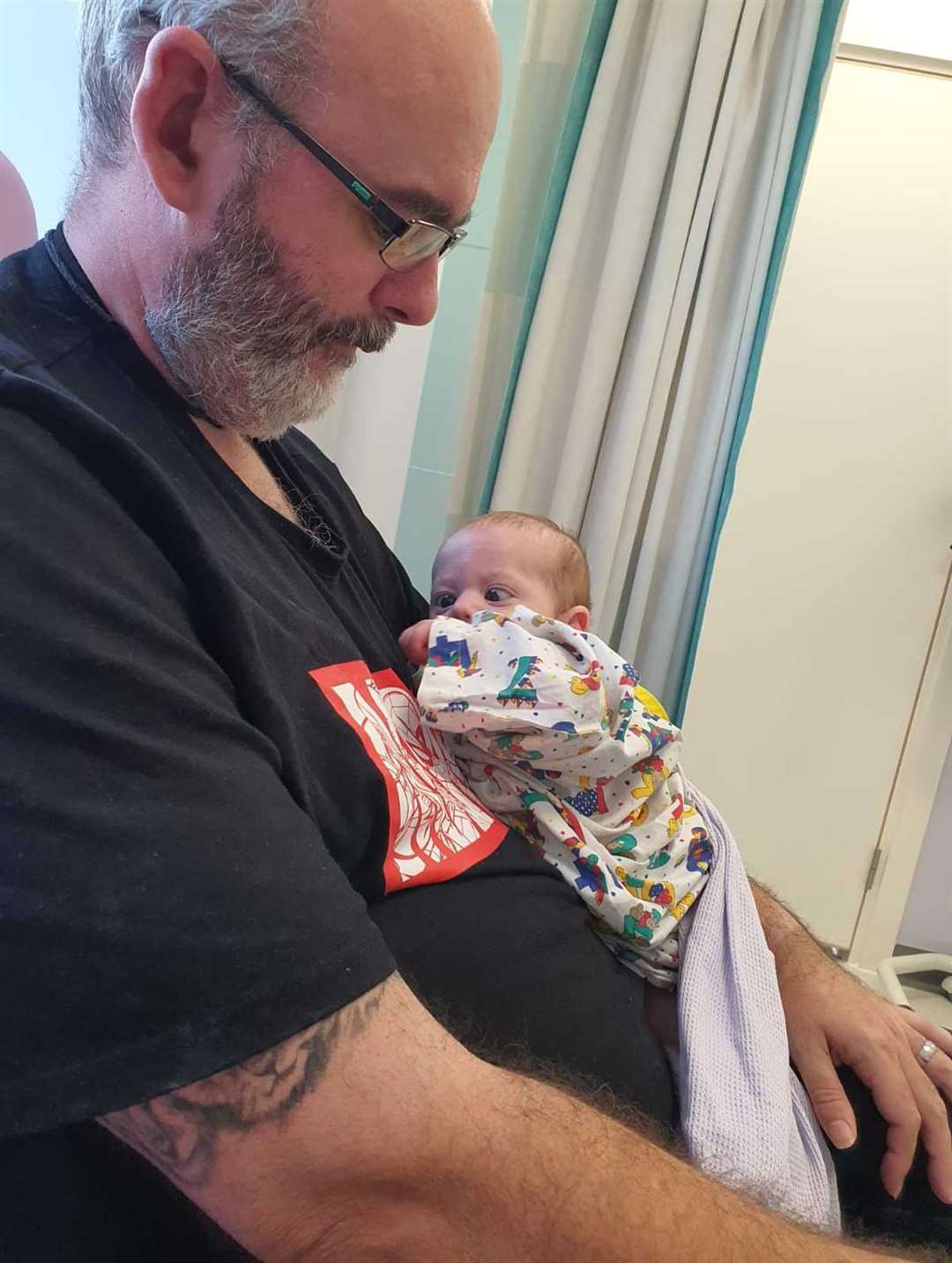 Baby Thomas pictured with his Dad in hospital while waiting for treatment to his eye cancer